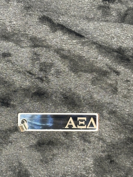 Metallic 'ΔΕΛ' emblem on a textured surface