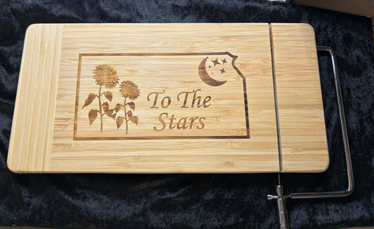Wooden cutting board with engraved design and text on a dark background