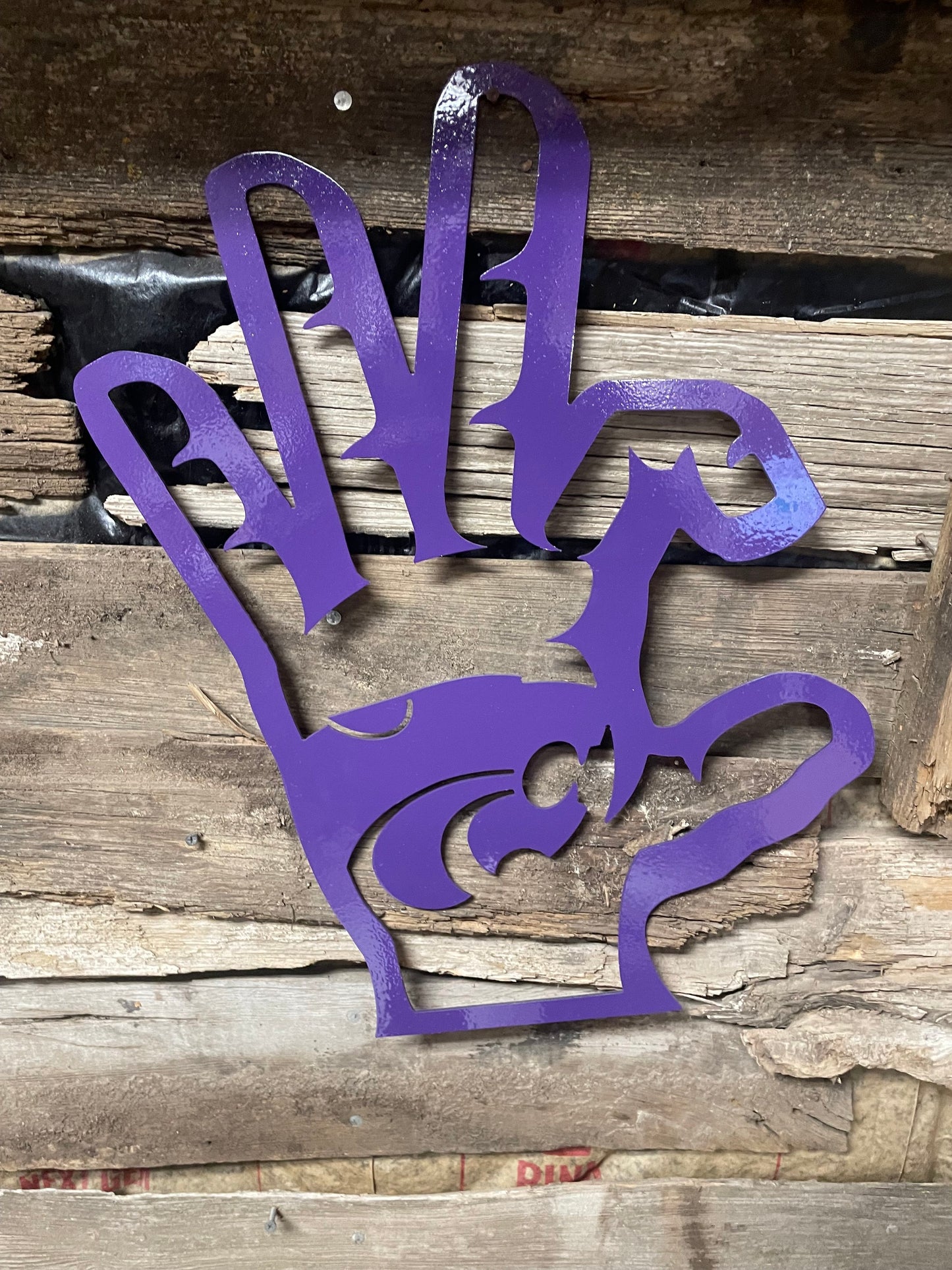 Wildcat hand with PowerCat metal sign